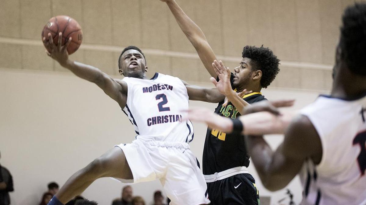 FILE PHOTO: Modesto Christian's Michael Pearson (2) drives on Tracy's Isiah Hawthorne for a score during the Modesto Christian Holiday Hoop Classic in Salida on Friday, Dec. 29, 2017.