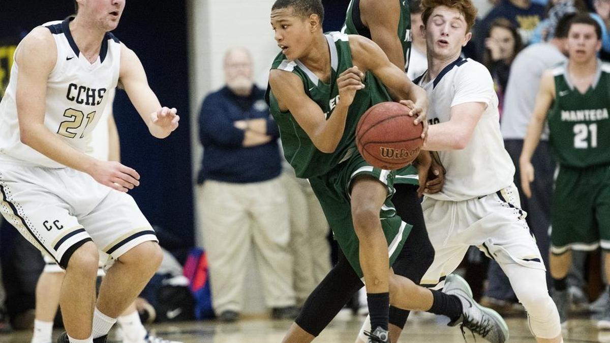 Manteca's guard Dwight Young moves off a screen as Central Catholic forward Peter Hamilton defends during the Valley Oak League game at Central Catholic High School in Modesto, Calif., on Wednesday, Feb. 17, 2016. Manteca won the game 54-53.