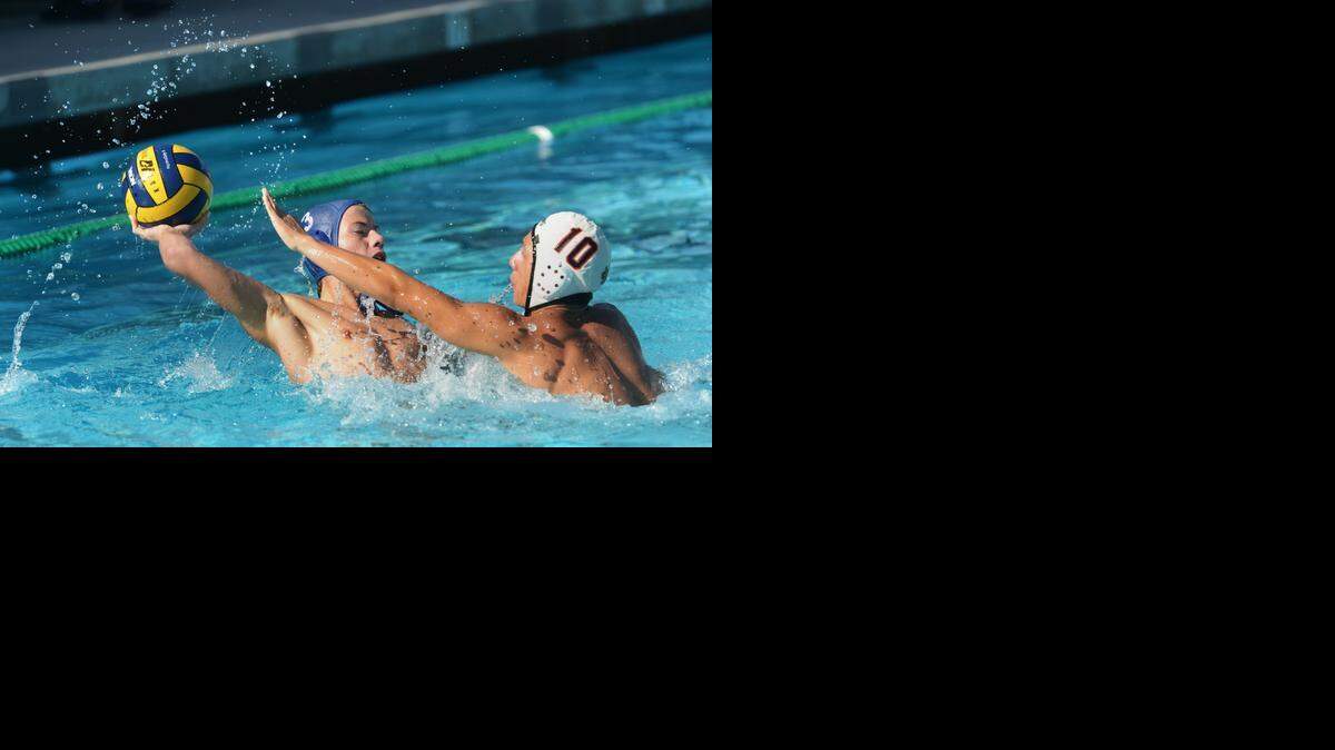 
Trevor Dixon of Downey looks for an opening over Chris Ybarra of Merced in water polo in the DeLong Tournament at the Downey pool, Oct. 24, 2014.
