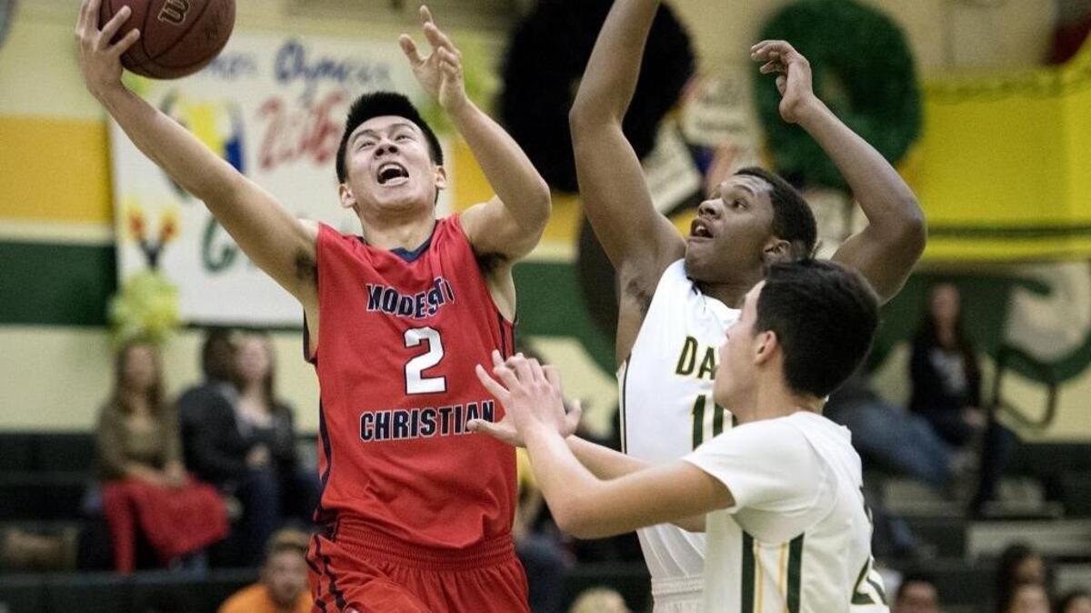 Modesto Christian guard Jay Chen drives to the hoop past Davis defenders Dhamond Bradford and Andres Sanchez in Wednesday’s Modesto Metro Conference basketball game. Modesto Christian ran its league winning streak to 150 consecutive games – a state record and the longest current streak in the nation – with an 88-43 victory. For more, see Page 4C.
