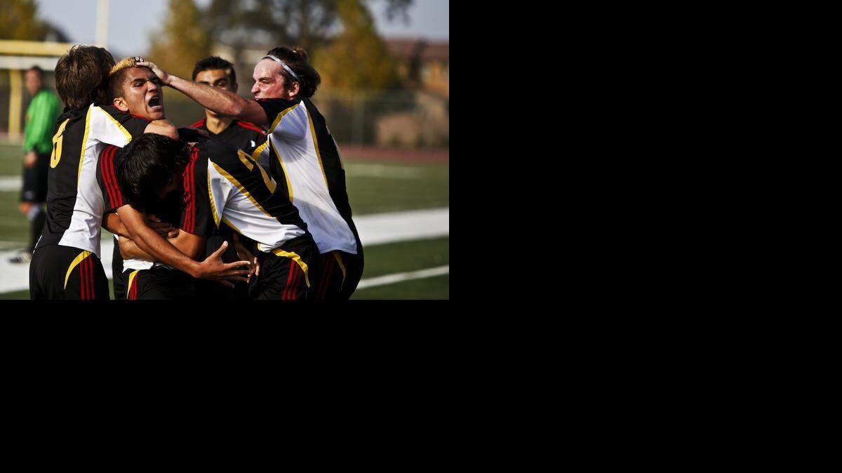 
Oakdale senior Jose Becerra (10) is hugged by teammates after scoring in overtime during a game against Christian Brothers in the 2014 CIF Sac-Joaquin Division III Soccer Tournament at Cosumnes Oaks High School in Elk Grove, Calif., Saturday, Nov. 15, 2014. The Mustangs beat the Falcons 2-1 in overtime.
