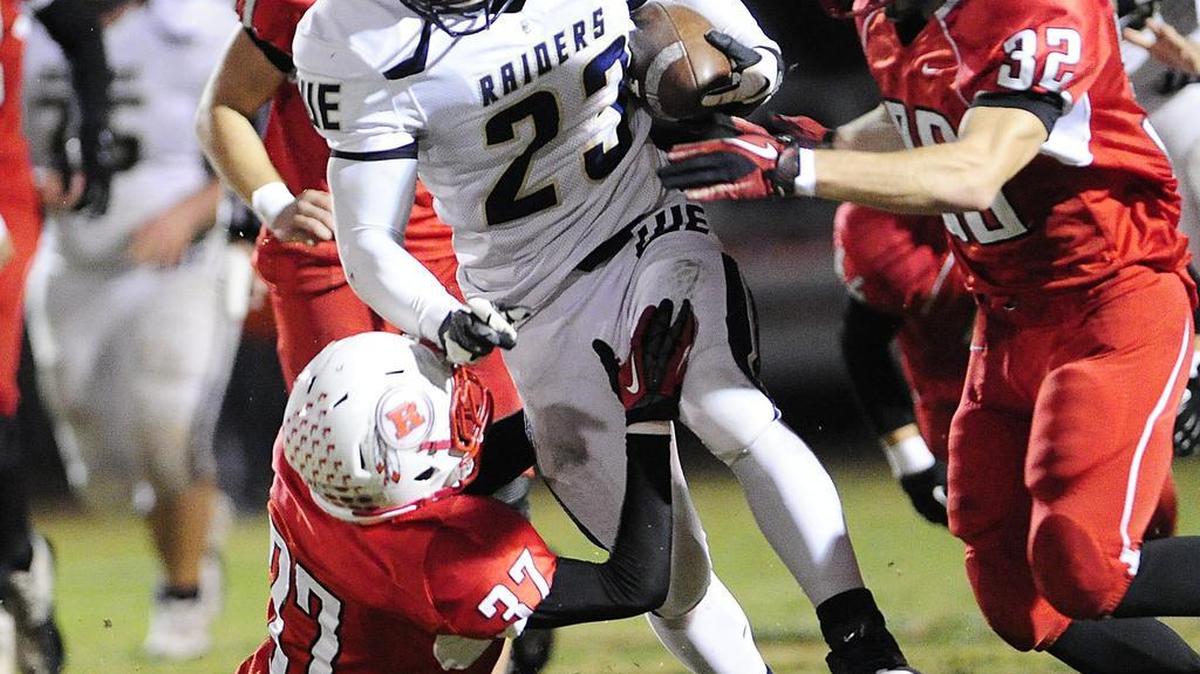 Central Catholic High’s Rey Vega, (23), rumbles for more yards against Ripon High's Josh Clark, (37), and Anthony Baciocco, (32), during the first half at Ripon High School's football field on Friday evening (11-16-12) in Modesto CA