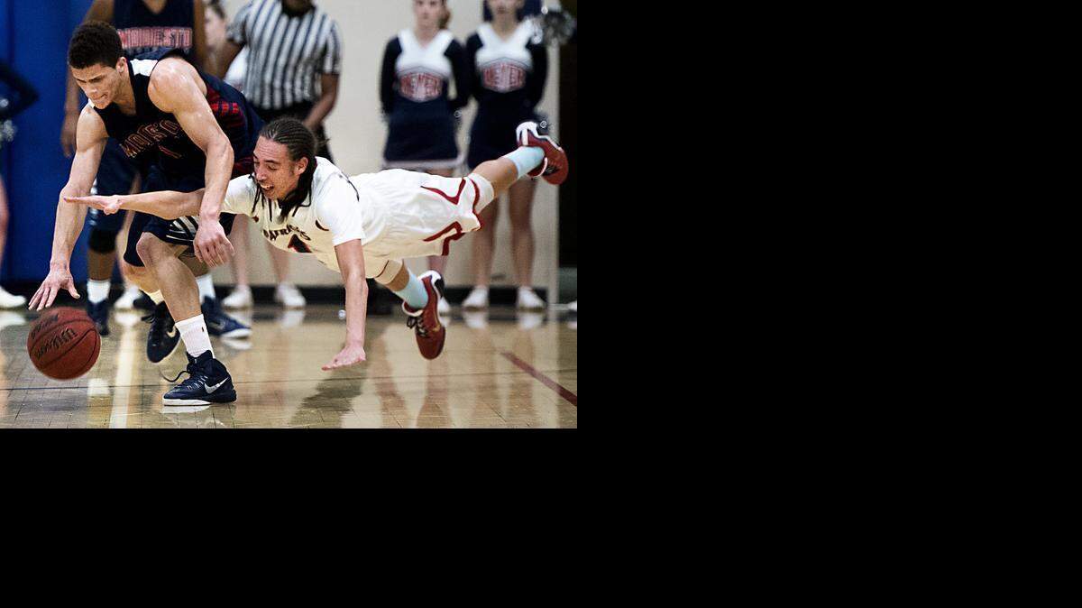 
Beyer guard George Dancer dives as Modesto Christian's Christian Ellis takes possession of a loose ball during the Modesto Metro Conference game at Beyer High School in Modesto on Jan., 21, 2015. Modesto Christian won the game 61-54.
