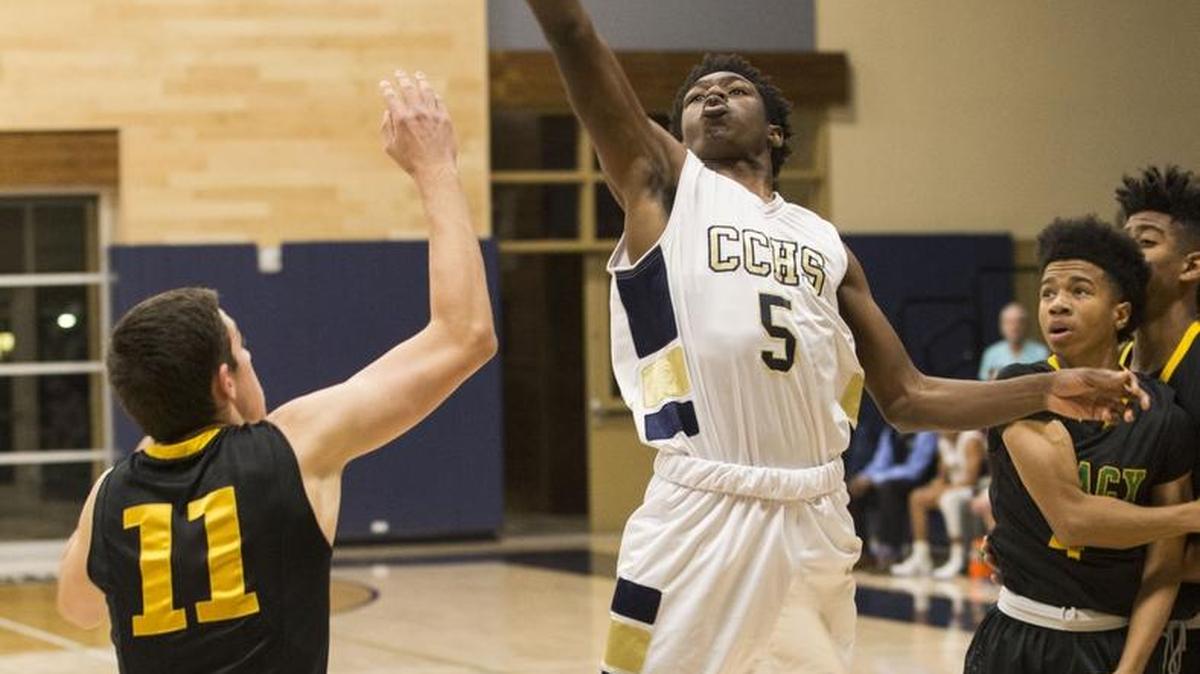 Daron Bland (5) of Central Catholic goes for two against Tracy High’s Matthew McDonald (11) during the Raiders’ 67-57 win on Thursday.