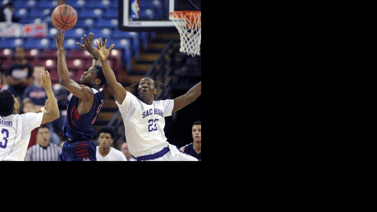 
Modesto Christian's Anthony Townes fights for a loose ball with Sacramento's Solomon Young during the CIF San-Joaquin Section Division II Championship where MC won 49-46 over Sacramento High at the Sleep Train Arena in Sacramento on March 7th, 2015 
