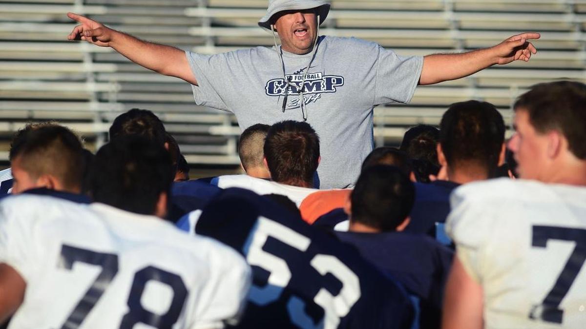 Downey coach Jeremy Plaa talks with his team after the camp about practice at the Downey Football Camp, at Chuck Hughes Stadium, July 9, 2014.
