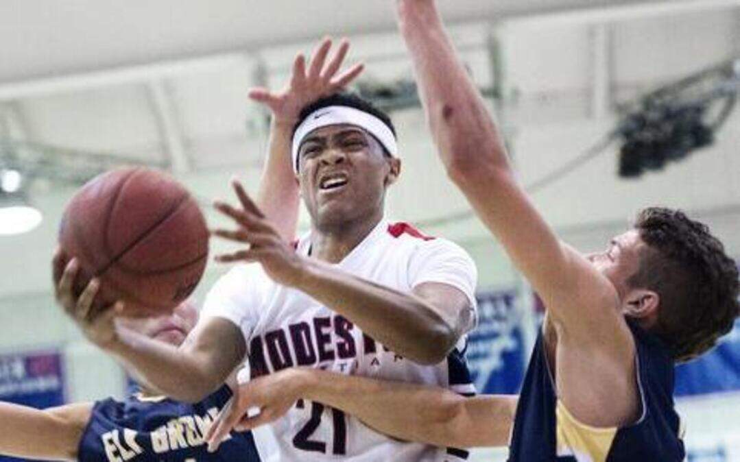 
Modesto Christian small forward Jordan Hollins-Buckner challenges Elk Grove defenders and is fouled during the Sac-Joaquin Section playoff game at Modesto Christian High School in Salida, Calif., on Friday, February, 27, 2015. MC won the game 79-47. 
