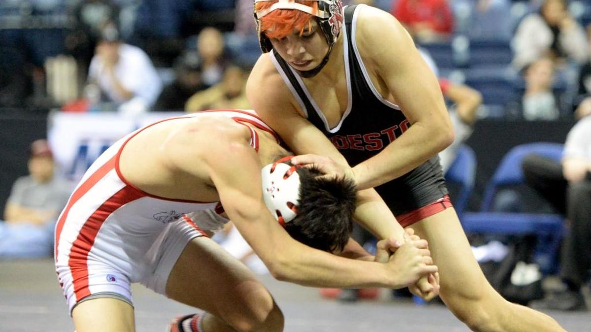 Modesto High’s Israel Saavedra takes down Curtis Booth of Folsom in the 126-pound finals during the Sac-Joaquin Section Masters Wrestling meet at the Stockton Arena last February.