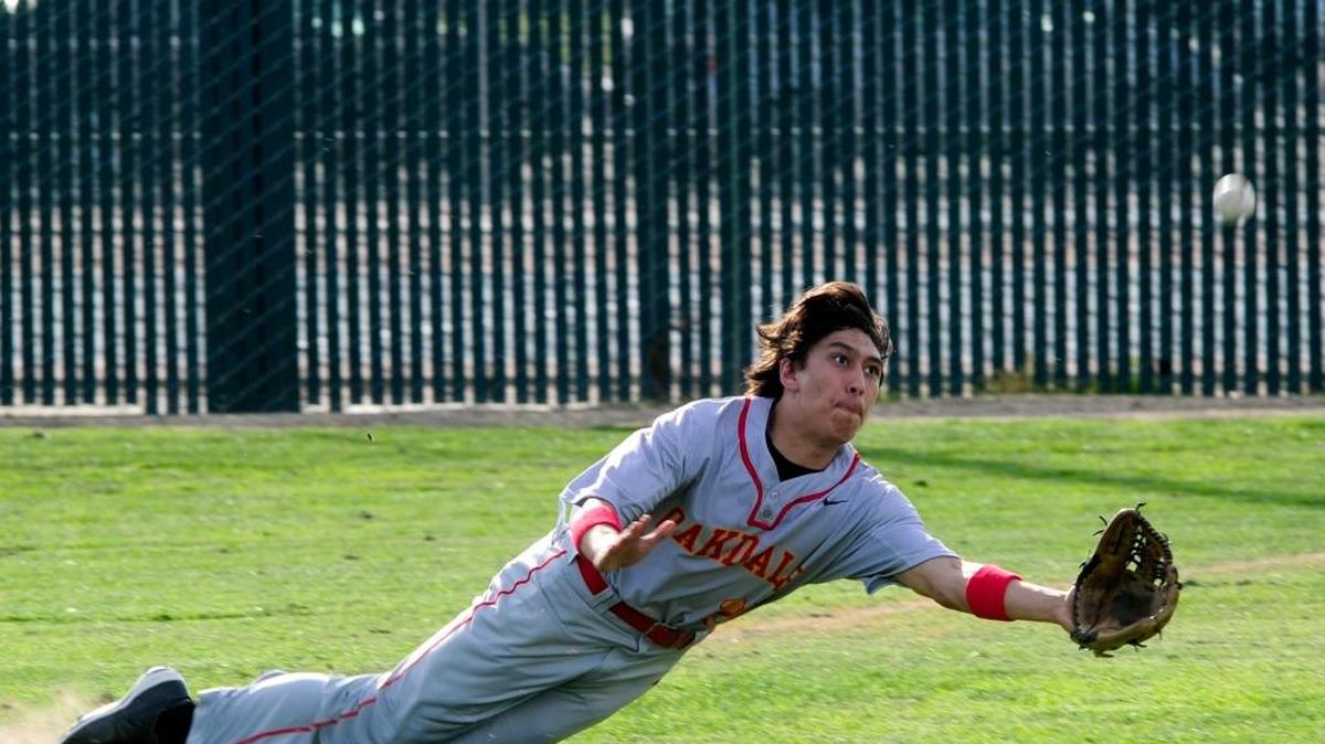 Oakdale right fielder Ben Solorio makes a diving attempt to catch a fly ball during the 2015 Pedretti Baseball Tournament game against host Turlock High. The 2016 tournament schedule has been moved ahead 24 hours to Wednesday, March 9, due to a forecast for rain on Friday.