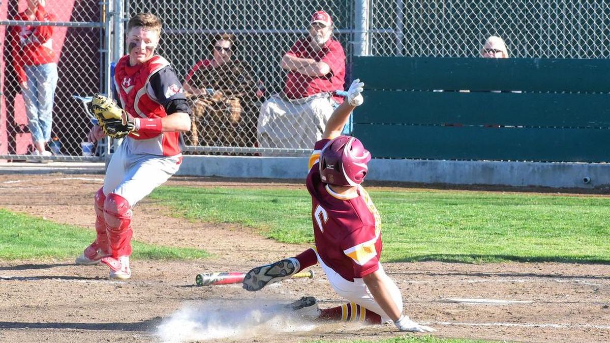 Los Banos' Julian Arrechavala (5) slides safely across the plate ahead of Ceres catcher Blane Abeyta's tag. Tuesday, March 29, 2017 in Los Banos.