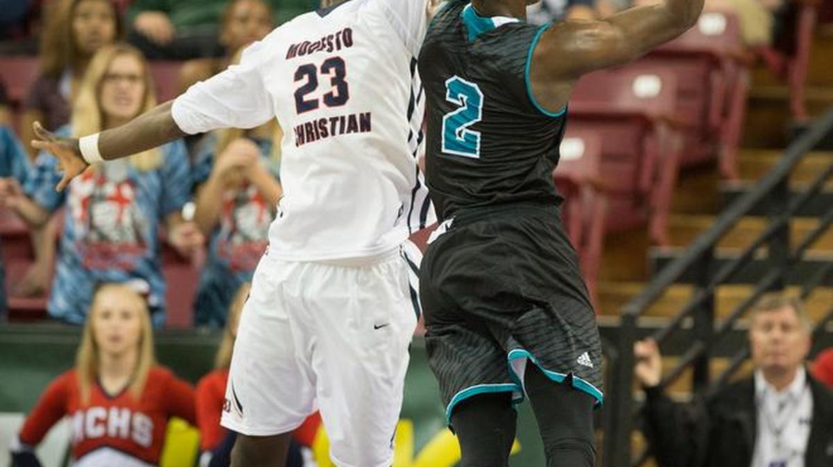 Modesto Christian’s Robinson Idehen tries to stop a drive by Sheldon’s Drew Cobb in the first half of Wednesday’s Sac-Joaquin Section Division I semifinal at Sleep Train Arena in Sacramento. The Crusaders won 74-67.