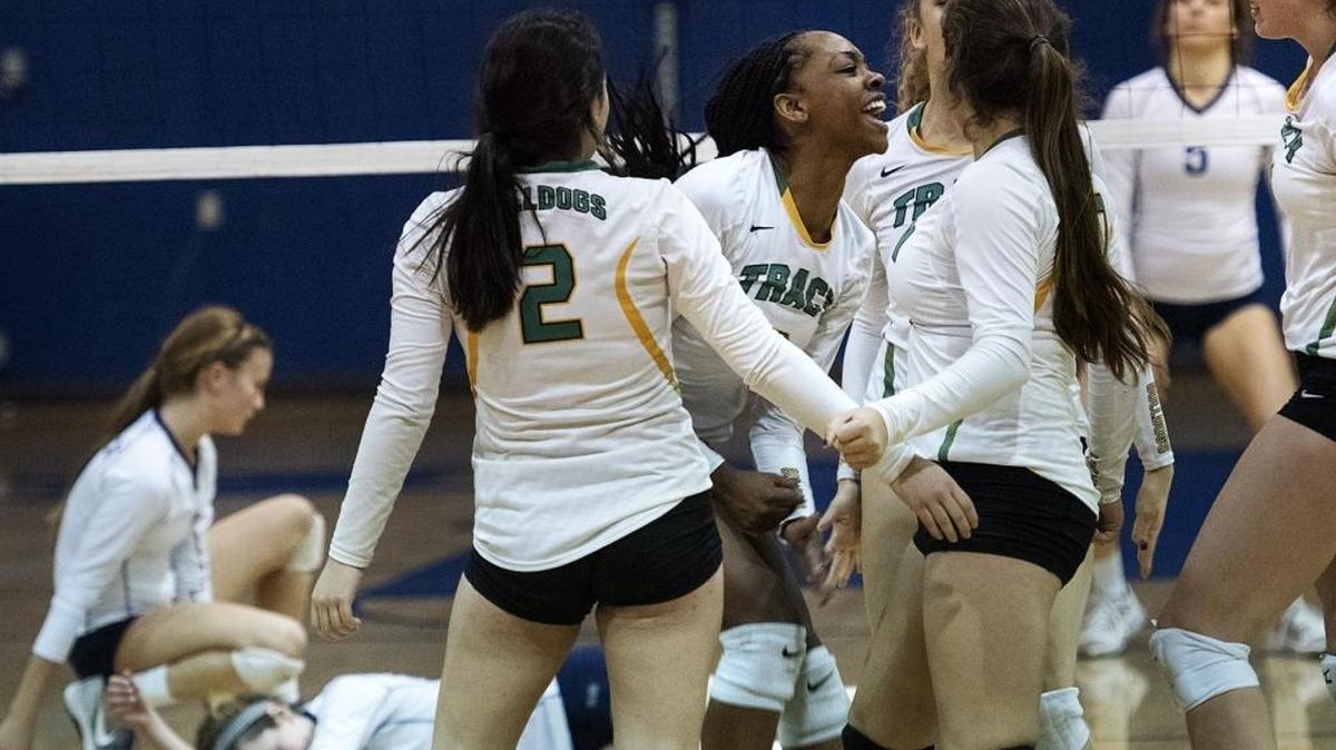 Tracy’s Jasmine Childress, middle, celebrates winning the second game with her teammates.