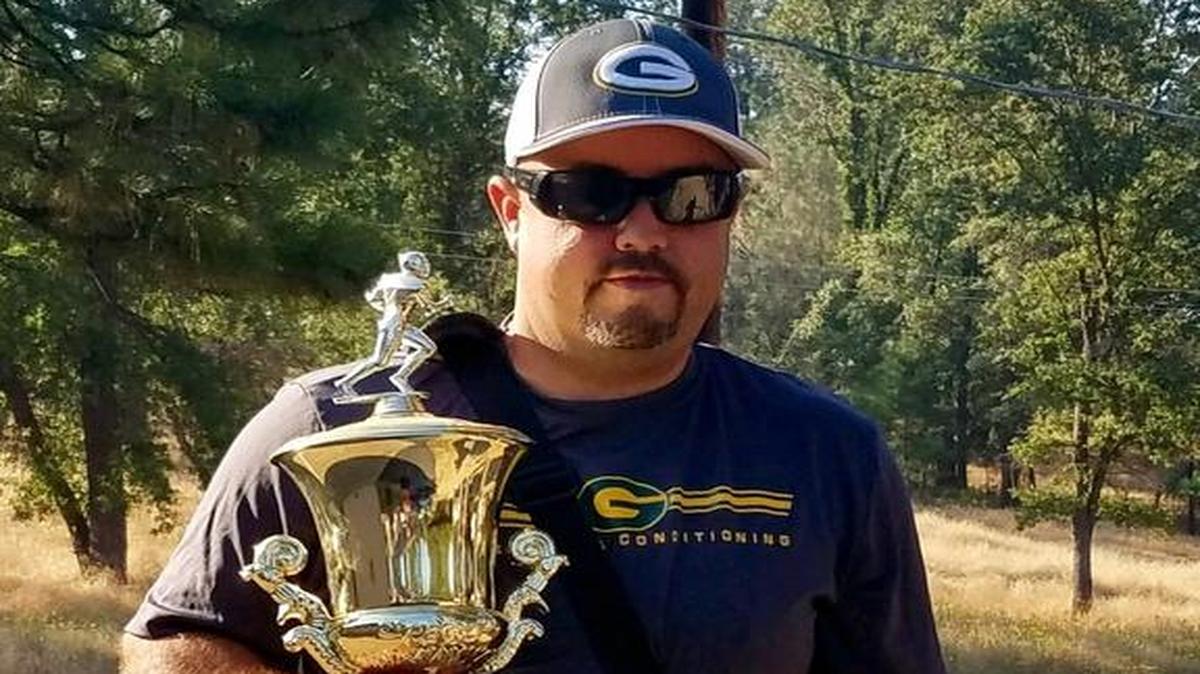 Mariposa High football coach Ryan Oliphant is pictured holding the Green and Gold Trophy, the prize awarded annually to the winner of the Mariposa-Le Grand rivalry game. Oliphant grabbed the trophy before he and his family were evacuated from their home on Tuesday because of the Detwiler fire.