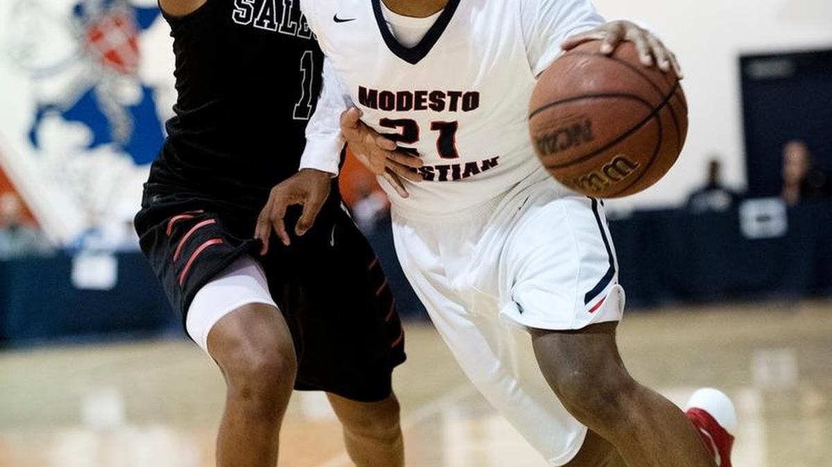 Modesto Christian’s Jordan Hollins-Buckner works the ball inside on Salesian defender James Akinjo during the Modesto Christian Holiday Hoops Classic in Modesto, Calif., on Tuesday, Dec. 29, 2015.