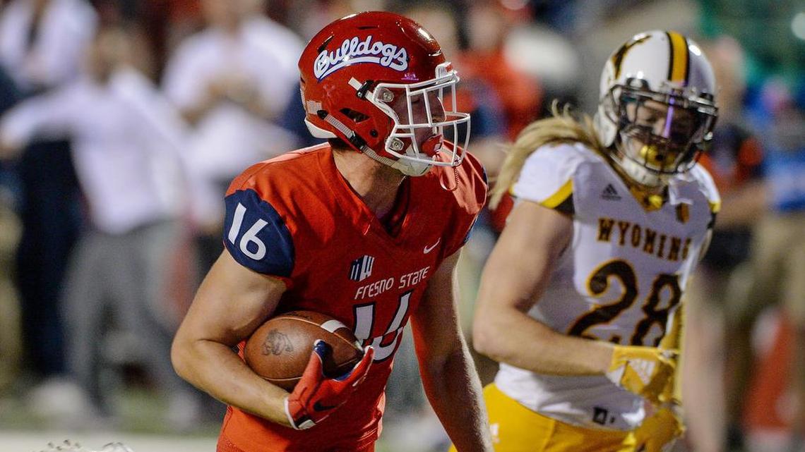 Fresno State’s Jared Rice, left, trots past Wyoming’s Andrew Wingard for a first half touchdown during their game at Bulldog Stadium in Fresno on Saturday, Oct. 13, 2018.