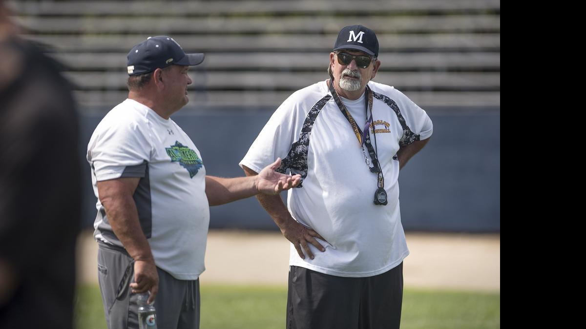 
Escalon's coach Mark Loureiro, right, talks with Central Catholic's Roger Canepa at the Mountain Misery football camp at Modesto’s Central Catholic High School on Friday. 


