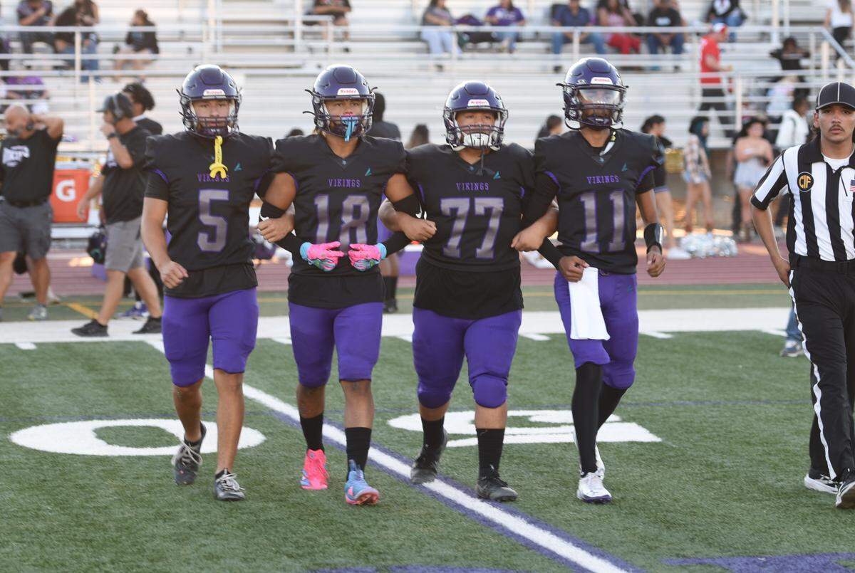 Johansen football captains head to midfield for the coin toss ahead of their matchup with Buhach Colony on Friday, Aug. 29, 2025.