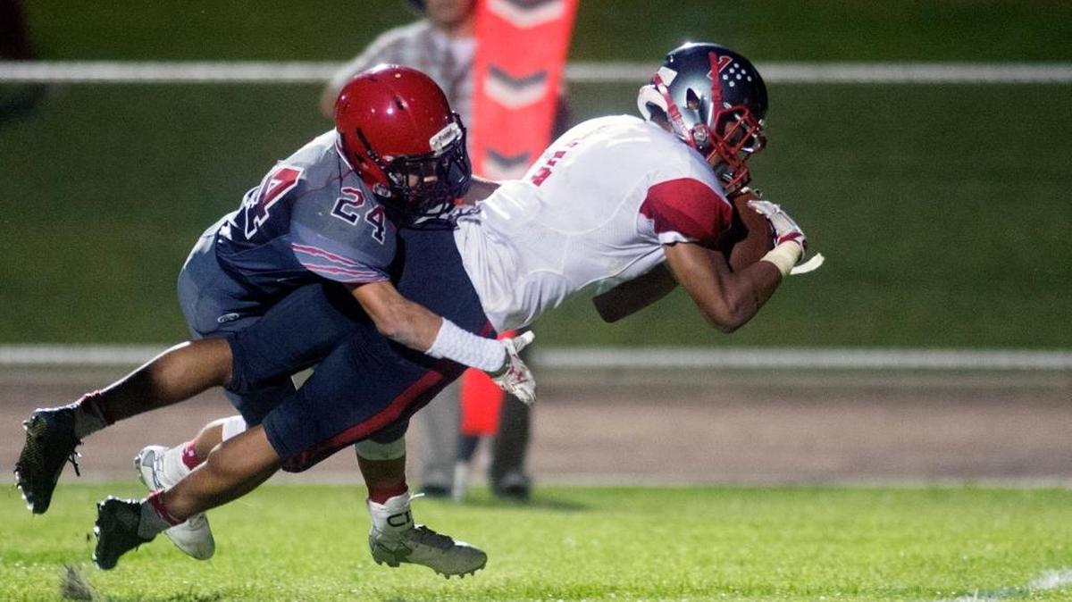 Patterson running back Jamal Broussard dives for the goal line while being held back by Modesto defensive back Roman Figueroa on Sept. 11, 2015, in Modesto, Calif. Patterson won 33-28.