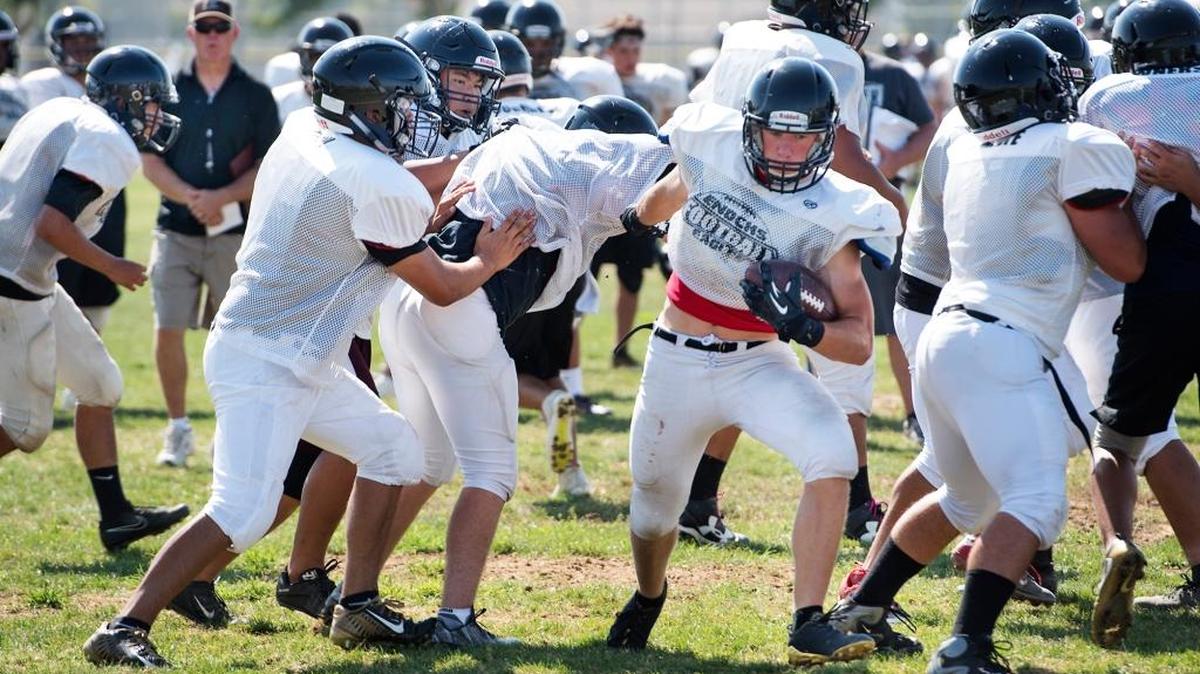 Enochs fullback Jacob Kenoyer runs the ball during practice at Enochs High School in Modesto on Wednesday.