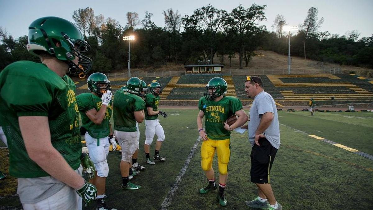 
Offensive coach Kirk Clifton gives the call to quarterback Sammy Page during football practice at Sonora High School last month.
