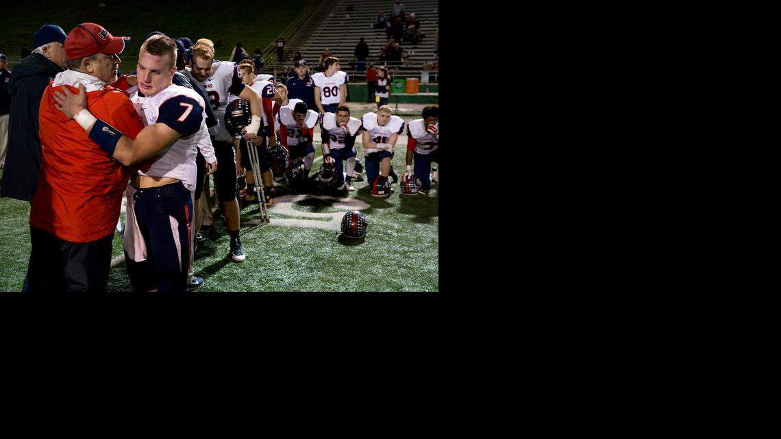 
Former coach and teacher Ron Megee consoles the senior players including Modesto Christian quarterback Luke Andrew (7) after the 35-28 loss to Capital Christian in the CIF Sac-Joaquin Section Division VI championship game at the Grape Bowl in Lodi on Saturday.
