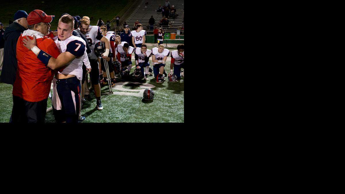 
Former coach and teacher Ron Megee consoles the senior players including Modesto Christian quarterback Luke Andrew (7) after the 35-28 loss to Capital Christian in the CIF Sac-Joaquin Section Division VI championship game at the Grape Bowl in Lodi on Saturday.
