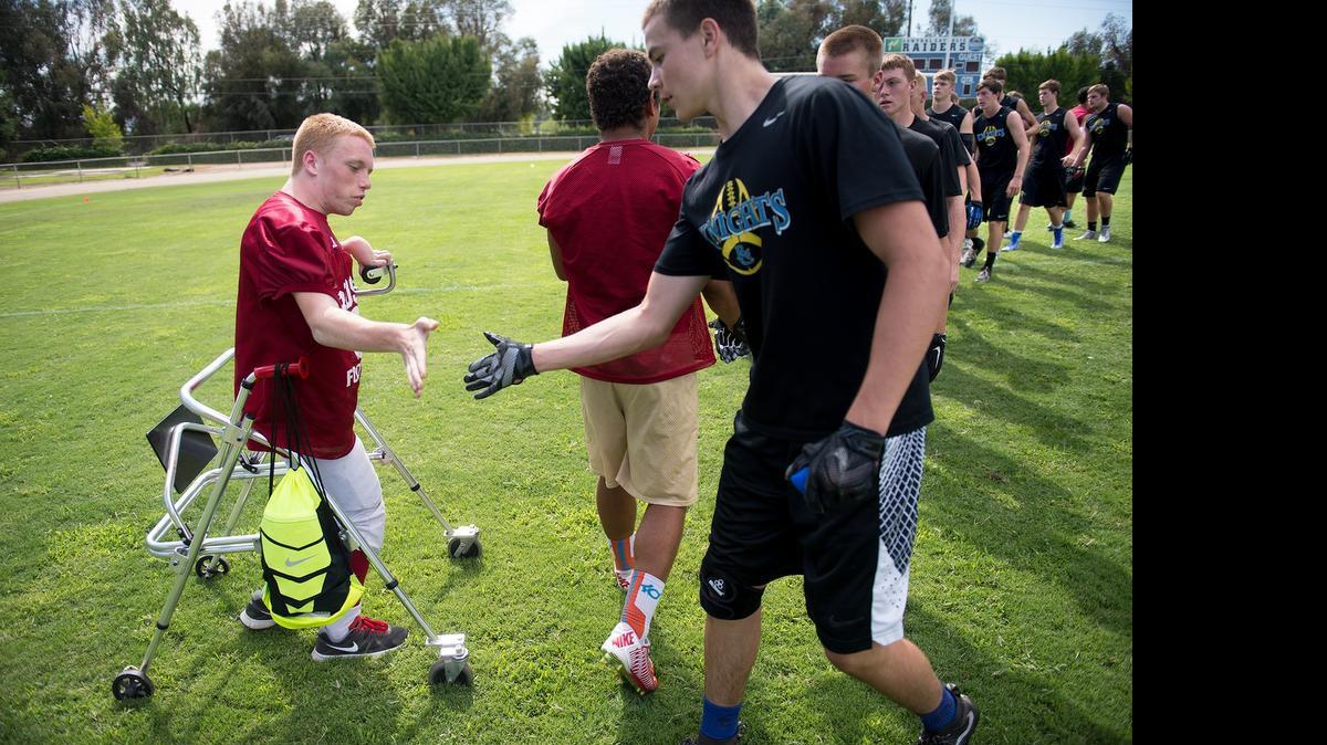 
Calaveras’ Kyle Chaboya shakes hands with members of the Ripon Christian football team after a scrimmage during the Mountain Misery football camp at Central Catholic High School in Modesto on July 17. Chaboya was born with cerebral palsy and knowing he will never be able to play in a game, he still suits up and supports his teammates.

