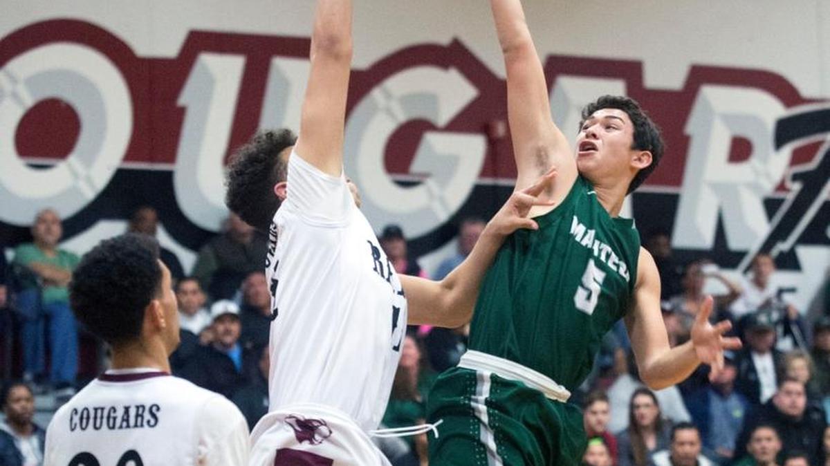 Manteca guard Angel Perez (5) floats the ball over a Weston Ranch defender during a game between Manteca and Weston Ranch in Stockton on Jan. 15, 2016.