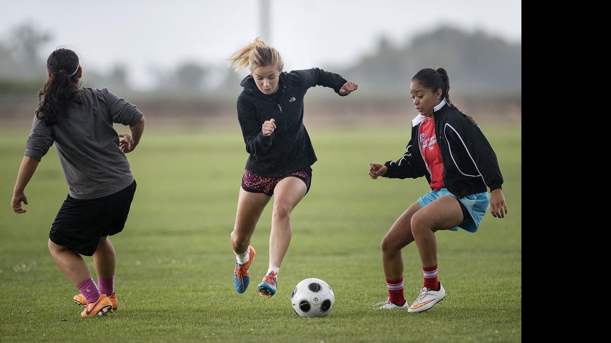 
Modesto Christian girls soccer team member Carsyn Hoogendoorn, middle, slips past teammates Ashley Lucas, right, and Aj Ovando, left, as they run drills during practice in Salidaon Thursday.
