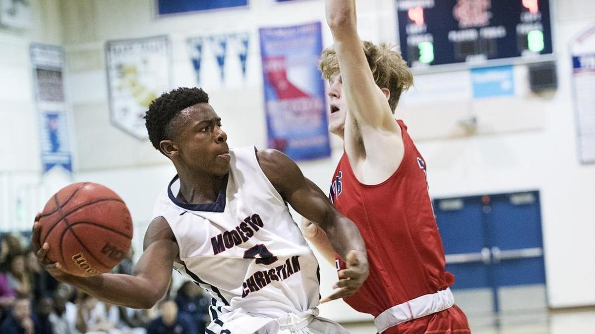Modesto Christian's Micheal Pearson passes the ball as Beyer's Kris Fore defends during the Modesto Metro Conference game in Salida on Wednesday, Jan. 24, 2018.