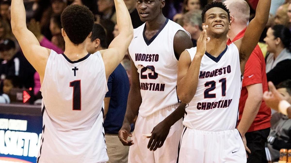 Modesto Christian’s Jordan Hollins Buckner (21), Robinson Idehen (23) and Christian Ellis (1) celebrate a teammate’s three-point bucket during the Modesto Metro Conference game at Modesto Christian High School on Jan. 20.