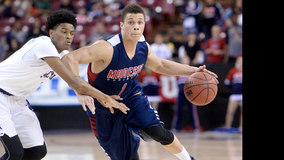
Modesto Christian guard Christian Ellis drives past Sacramento guard Raphael Durr during the CIF Sac-Joaquin Section Division II championship at Sleep Train Arena in Sacramento on March 7. The Crusaders won 49-46.
