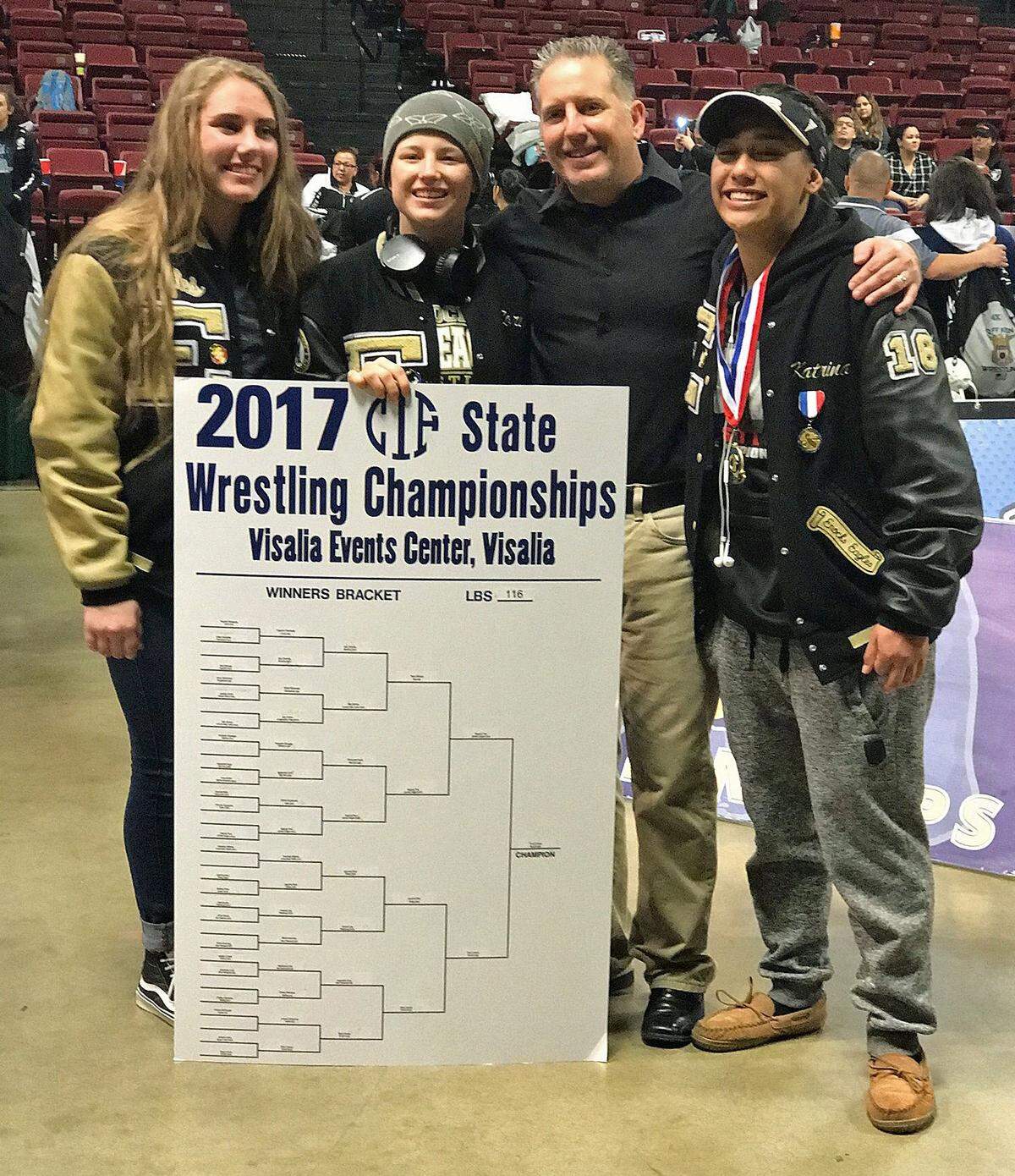 Enochs High School wrestling coach Duane Brooks, surrounded by Eagle wrestlers, from left, Kaitlain Gilmour, Rory Coscia and Katrina Guevara, is all smiles after the CIF State Meet. On Thursday April 6, 2017, he was named NorCal Coach of the Year.