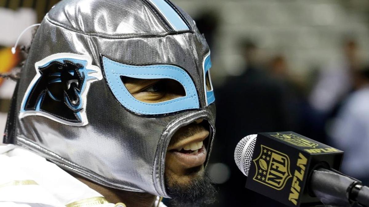Carolina Panthers cornerback Josh Norman wears a mask at the request of a Hispanic reporter as he answers a question during Super Bowl opening night on Monday, Feb. 1, 2016, in San Jose.