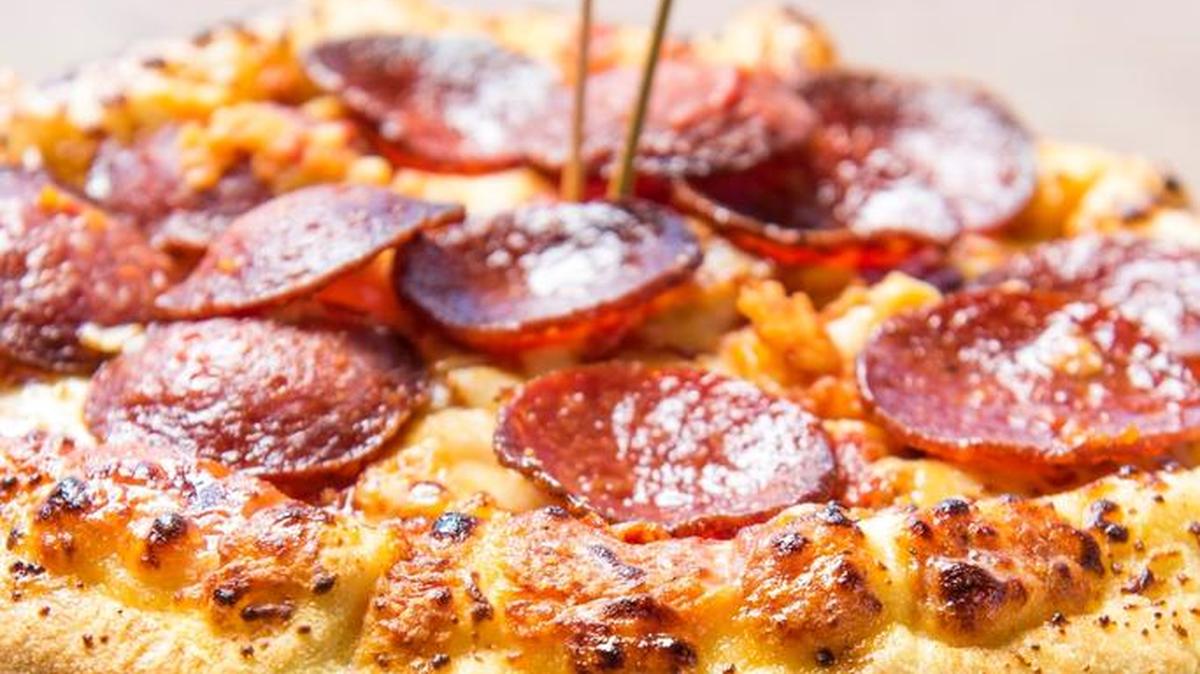 In this photo released by the Atlanta Braves, the “Burgerizza” is shown in Atlanta. A grilled 20-oz. all-beef patty, covered with five slices of cheddar cheese, topped with crispy bacon, and served between two 8-inch pepperoni pizzas is one of many new items that will be for sale during the team’s final season at Turner Field.