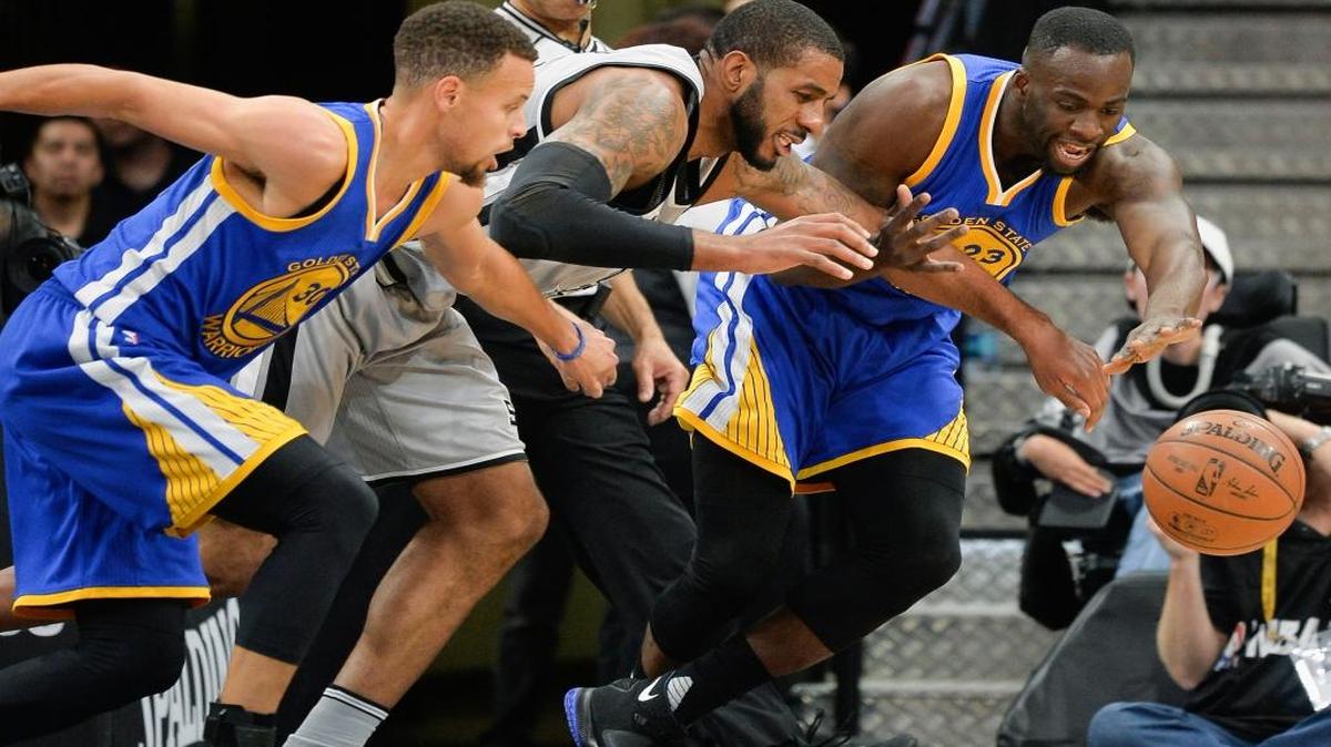 San Antonio Spurs forward LaMarcus Aldridge, center, chases the ball against Golden State Warriors' Stephen Curry (30) and Draymond Green during an NBA basketball game, Saturday, March 19, 2016, in San Antonio.
