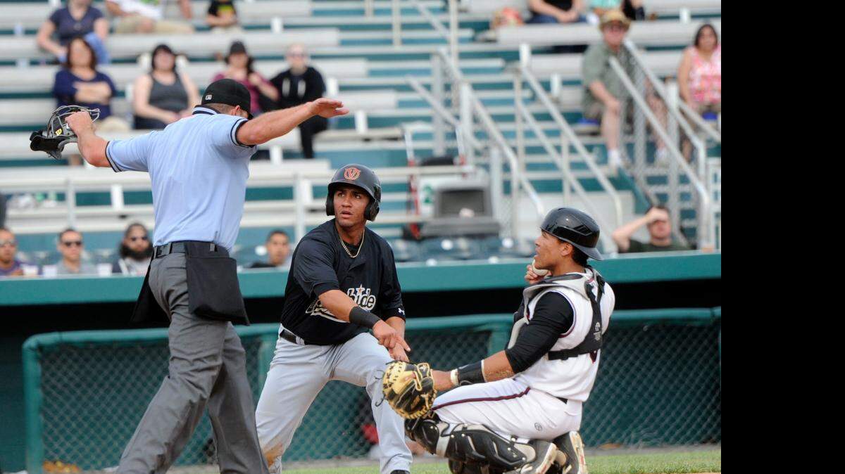
The umpire calls Rawhide's Micheal Perez safe after Nuts catcher Wilfredo Rodriguez lost control of the ball during a game between the Modesto Nuts and Visalia Rawhide at John Thurman Feld in Modesto on April 22, 2015.

