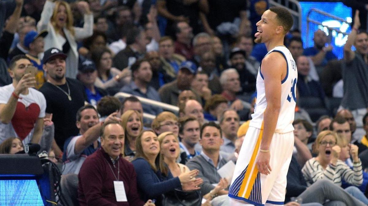 Golden State Warriors guard Stephen Curry celebrates after making a three-pointer from near the half-court line at the end of the third quarter of Thursday’s 130-114 victory over the Magic in Orlando, Fla. Curry scored 51 points, including 10 three-pointers.