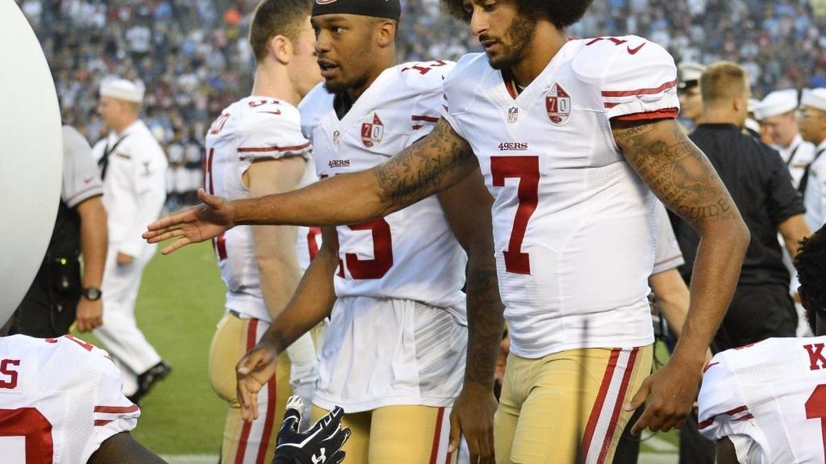 San Francisco 49ers quarterback Colin Kaepernick greets teammates after kneeling during the national anthem before the team's NFL preseason football game against the San Diego Chargers, Thursday, Sept. 1, 2016, in San Diego.