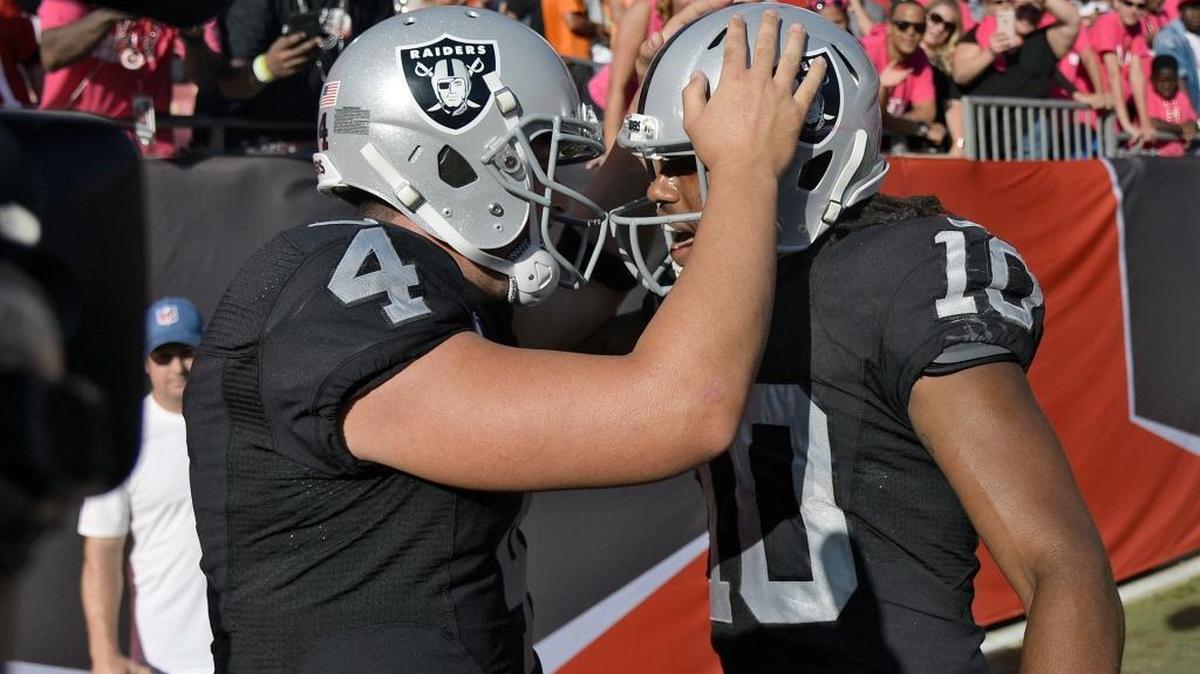 Oakland Raiders quarterback Derek Carr (4) celebrates with wide receiver Seth Roberts (10) after Roberts caught the game-winning 41-yard touchdown pass against the Tampa Bay Buccaneers during overtime in an NFL football game Sunday, Oct. 30, 2016, in Tampa, Fla.
