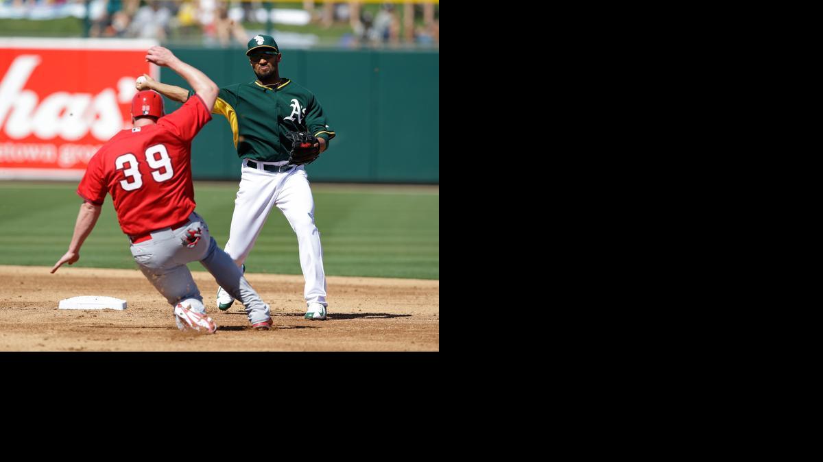 Los Angeles Angels' Marc Krauss (39) is forced out at second as Oakland Athletics' Marcus Semien throws to first during the third inning of a spring training baseball game Saturday, March 7, 2015, in Mesa, Ariz. Roger Kieschnick was out at first for the double play. (AP Photo/Darron Cummings)