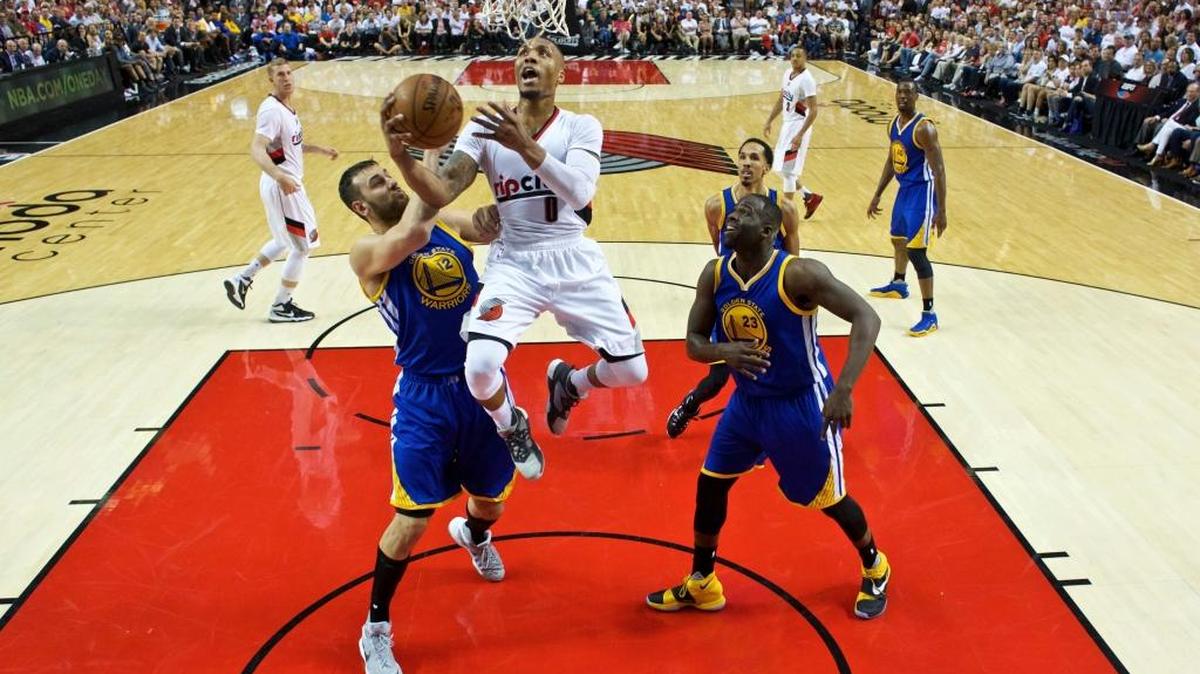 Portland Trail Blazers guard Damian Lillard, center, shoots past Golden State Warriors center Andrew Bogut, left, and forward Draymond Green, right, during the first half of Game 3 of an NBA basketball second-round playoff series Saturday, May 7, 2016, in Portland, Ore. Lillard scored a game-high 40 points.