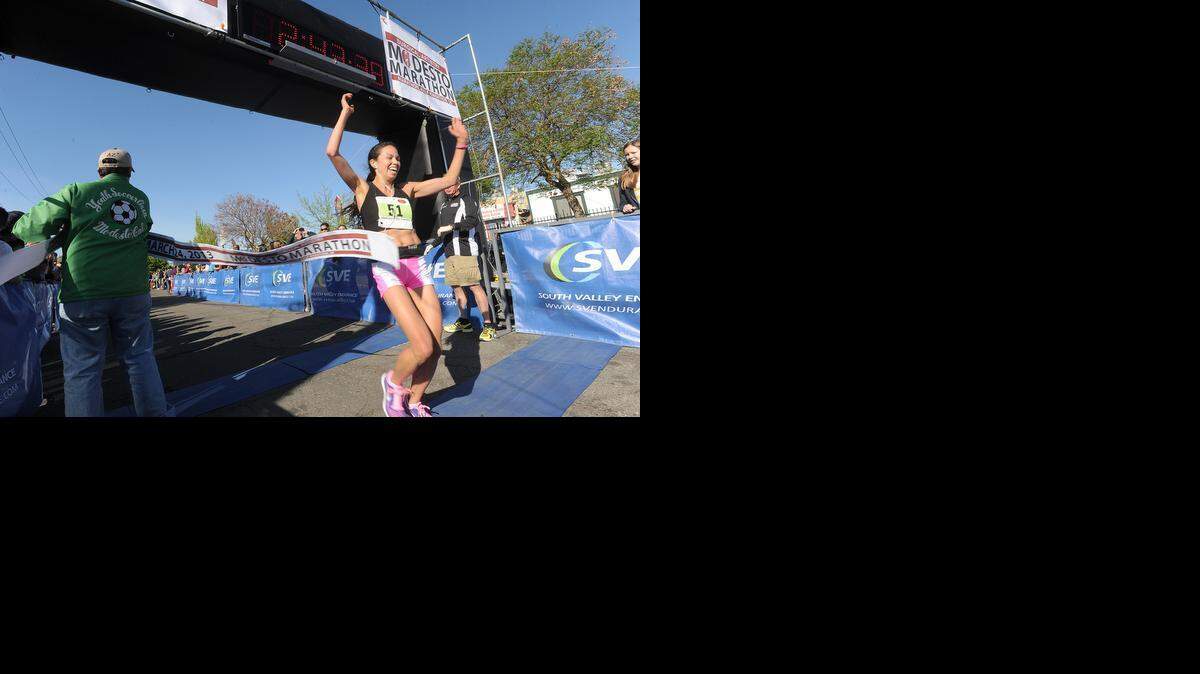 <137>ELIAS FUNEZ/efunez@modbee.com <137>Berkeley’s Anna Bretan crosses the finish line along M Street in downtown Modesto to win the women’s marathon in 2013. <137>first for the women in the 26 mile full marathon with a time of 2 hours and 43 minutes Sunday (03-24-13).<137>