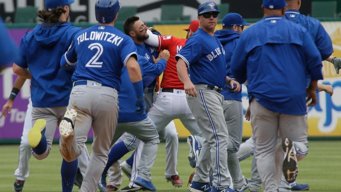 Members of the Toronto Blue Jays (in blue) and Texas Rangers brawl on the field in the eighth inning of Sunday’s game in Arlington, Texas.