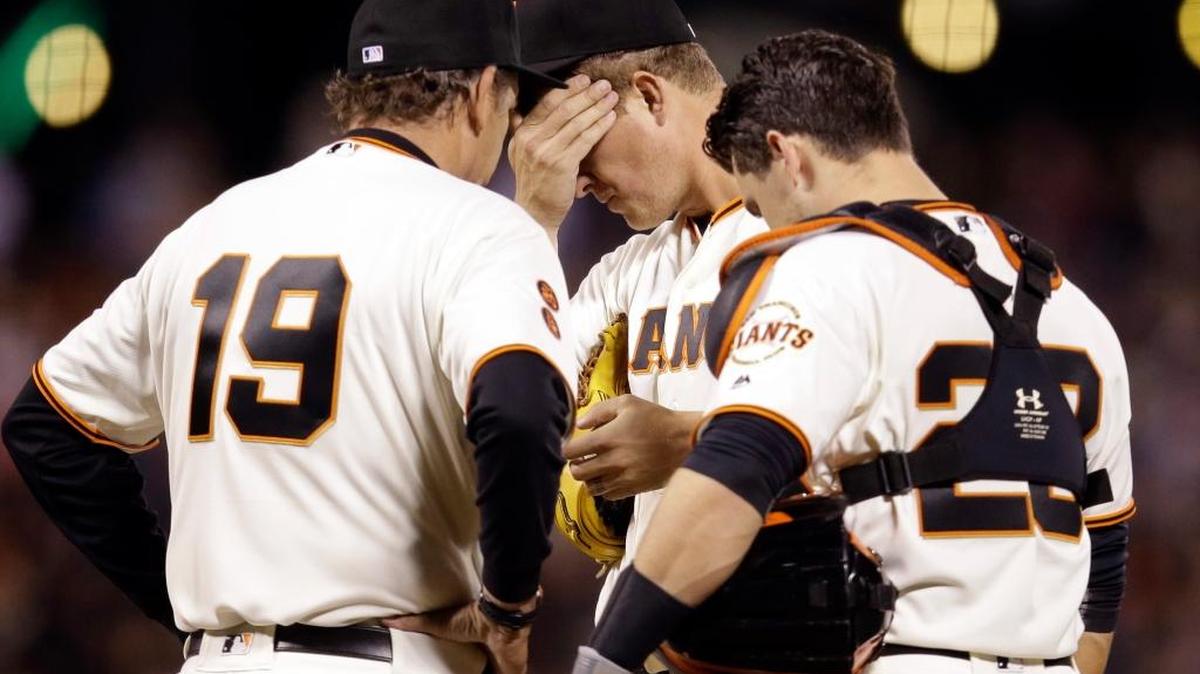 Giants starting pitcher Matt Cain, center, gets a visit to the mound from pitching coach Dave Righetti (19) and catcher Buster Posey after Cain gave up a double to Colorado Rockies’ Carlos Gonzalez during the fifth inning Thursday in San Francisco.