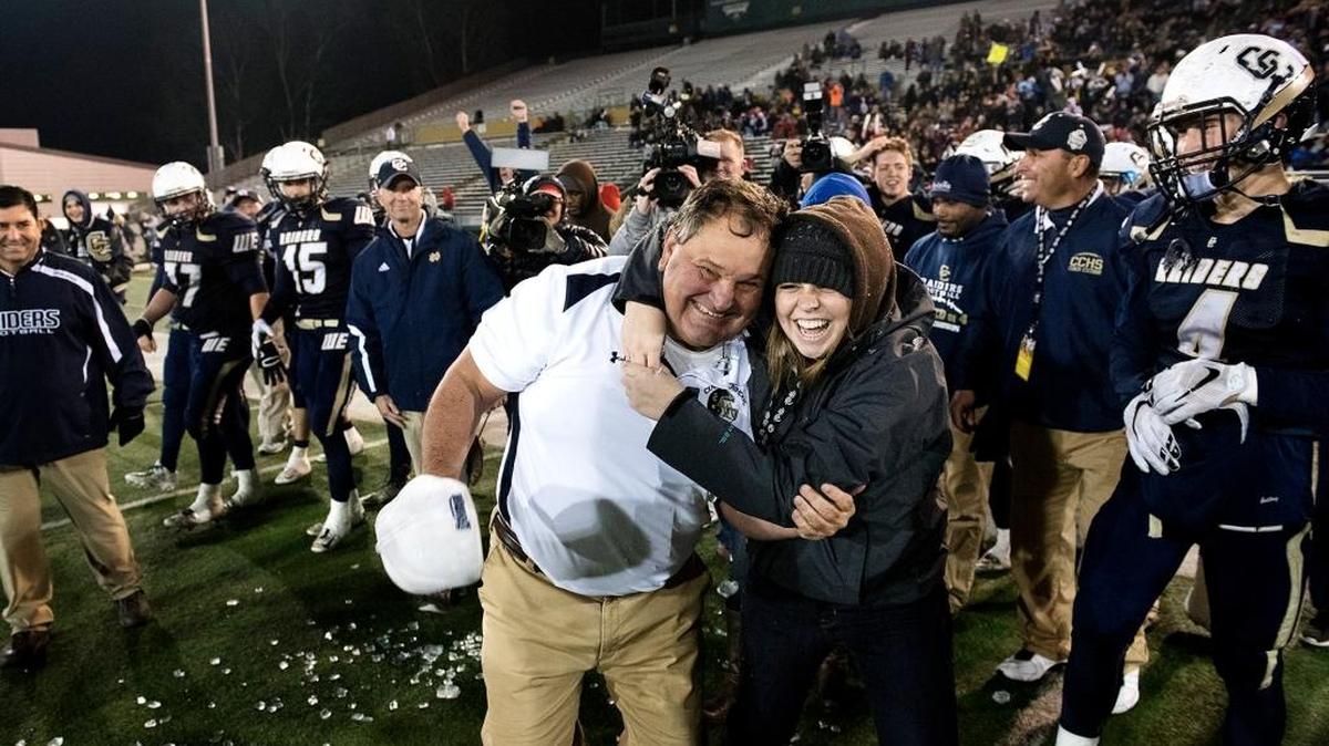 Central Catholic football coach Roger Canepa gets a hug from his daughter, Alexis Canepa, after the Raiders defeated San Marino to claim the CIF Open Division-Small School championship on Saturday, Dec. 19, 2015, at Sacramento State University in Sacramento, Calif.