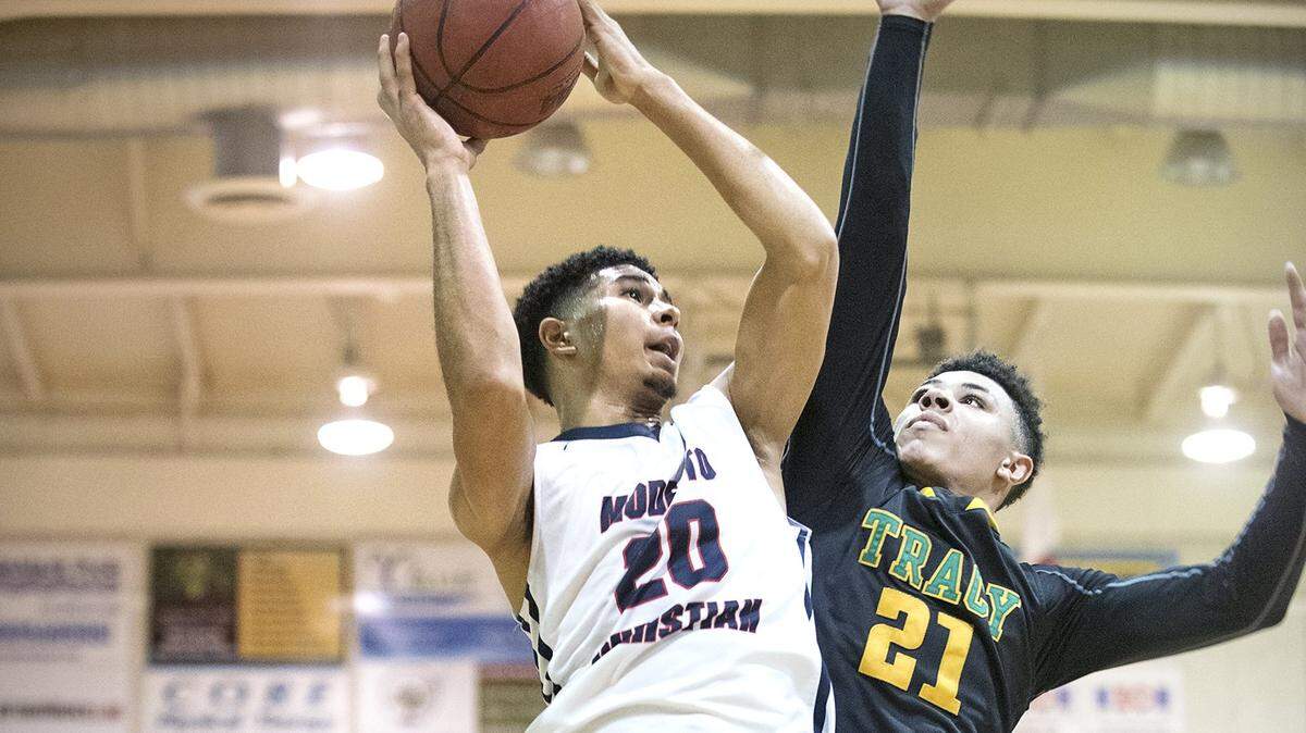 Modesto Christian's Dathan Satchell scores over Tracy's Miles Turner during the Modesto Christian Holiday Hoops Classic in Salida on Friday, Dec. 29, 2017.